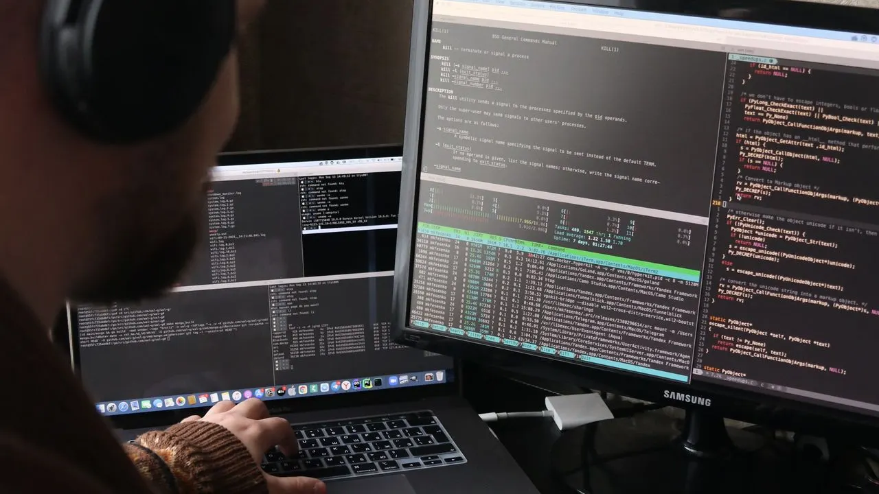 Developer working across two monitors filled with code