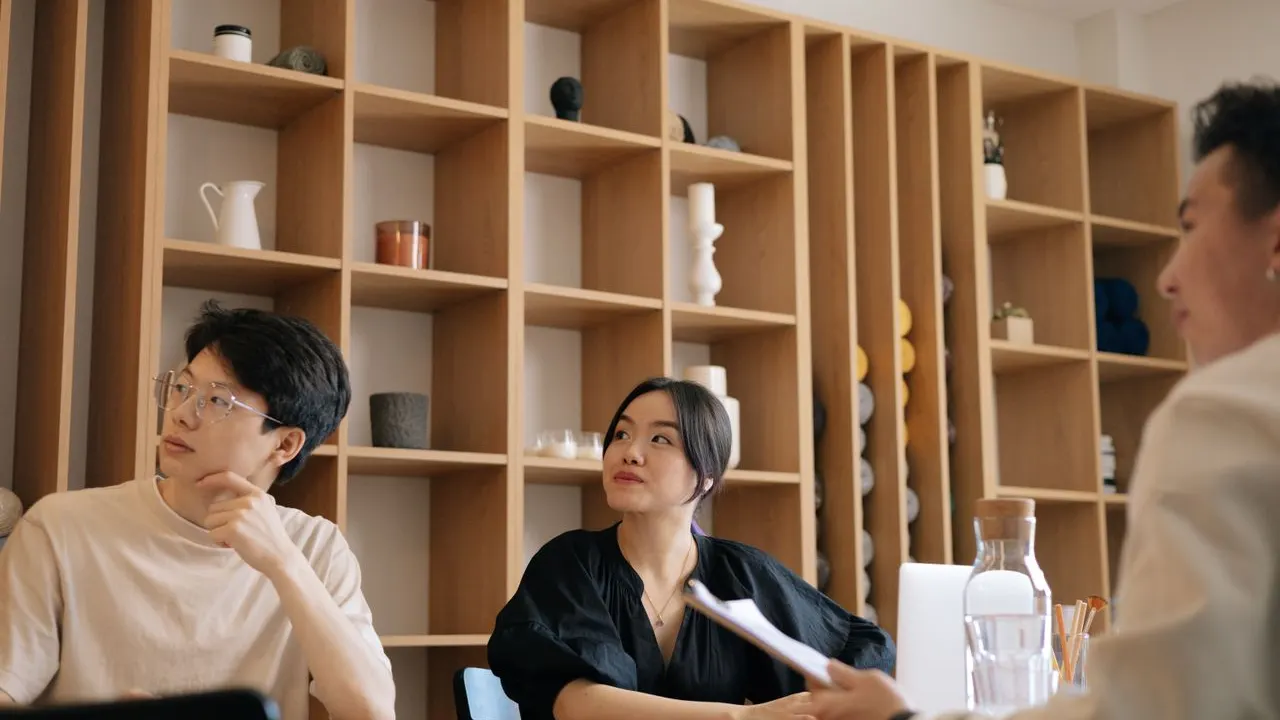 Team discussing a project around a table in a bright office